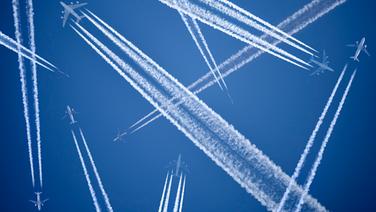 Eine Montage zeigt Flugzeuge und Kondensstreifen am Himmel © imago images/Christian Ohde 
