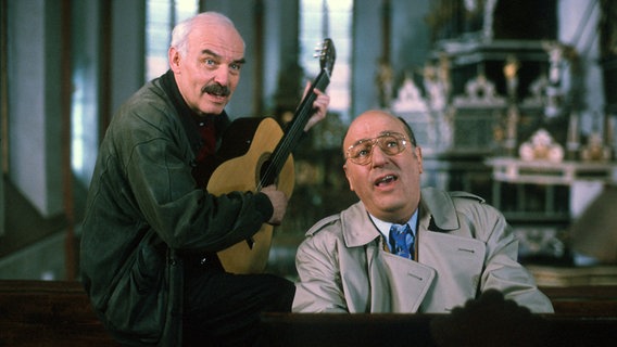 Entspannt singen die "Tatort"-Kommissare Stoever (Manfred Krug, rechts) und Brockmöller (Charles Brauer, links) ein Ständchen zu Ehren der Jungfrau Maria. Folge: "Rattenlinie", 2000 © NDR/Manju Sawhney 