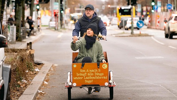 Bjarne Mädel transportiert Anke Engelke in einem Lastenfahrrad durch eine Großstadt © SWR/2Pilots/Martin Rottenkolber 