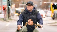 Bjarne Mädel transportiert Anke Engelke in einem Lastenfahrrad durch eine Großstadt © SWR/2Pilots/Martin Rottenkolber 