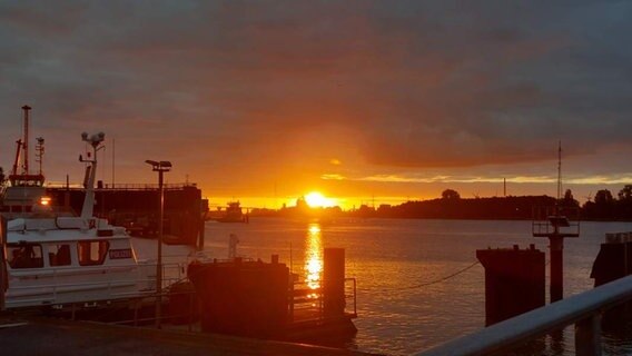 Die Sonne geht über dem Nord-Ostsee-Kanal auf und taucht das Wasser, den Himmel und ein Polizeiboot in intensives orange. © NDR 2 Foto: NDR 2 Hörer Reiner