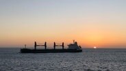 Die Sonne geht über der Elbmündung auf, im Vordergrund ein Frachtschiff © Privat Foto: NDR 2 Hörer Arne Voss