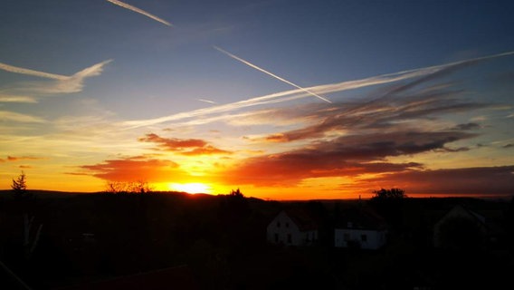 Intensiver Sonnenaufgang über einer Wohnsiedlung, fotografiert aus einem Dachfenster © Privat Foto: NDR 2 Hörerin Viola