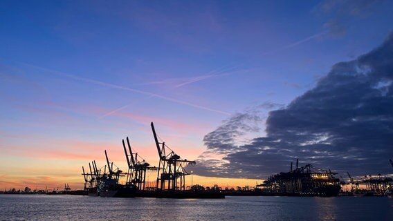 Sonnenaufgang vor blauem Himmel im Hamburger Hafen mit großen Kränen im Hintergrund © Privat Foto: NDR 2 Hörerin Anna