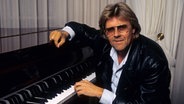 Der Schlagersänger und Komponist Howard Carpendale sitzt lässig an einem Klavier. © IMAGO / APress 