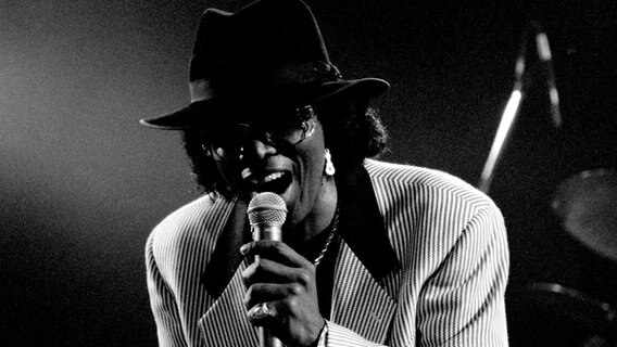 Johnny Guitar Watson © Thomas Halfmann [CC BY-SA (https://creativecommons.org/licenses/by-sa/2.0)] 