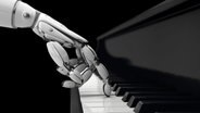 Eine Roboterhand drückt eine Taste auf einem Klavier, Themenbild zu Künstlicher Intelligenz und Musik © IMAGO / Science Photo Library 