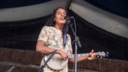 Die Musikerin Leyla McCalla singt auf einer Bühne. © picture alliance/AP Images | Amy Harris 