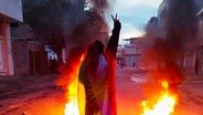 Eine Frau zeigt während einer Demonstration in Sanandadsch im Iran das Victory-Zeichen. © picture alliance / abaca | SalamPix/ABACA 