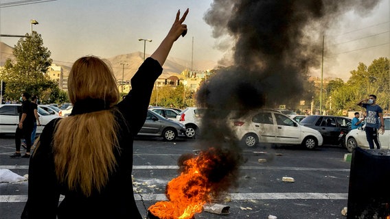 Eine Frau zeigt während einer Demonstration im Iran das Victory-Zeichen. © picture alliance / ASSOCIATED PRESS | Uncredited 