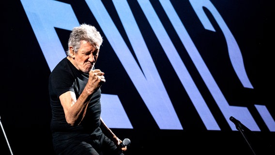 Roger Waters bei einem Auftritt im Mai in Hamburg bei der Tour "This is a not drill" - im Hintergrund das Wort "Evil?" auf der Leinwand © Foto: Daniel Bockwoldt/dpa +++ dpa-Bildfunk +++ Foto: Daniel Bockwoldt