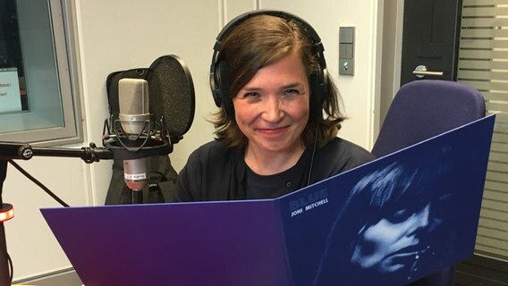 Die Musikerin Stefanie Hempel hält einem Studio des NDR das Album "Blue" von Joni Mitchell in der Hand. © Angela Gobelin Foto: Angela Gobelin