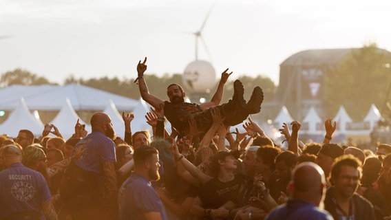 Ein Mann wird auf dem Wacken Festival vom Publikum getragen. © IMAGO / Dirk Jacobs 