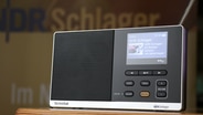 Ein eingeschaltetes Dabbi DAB+ Radio mit NDR Schlager Stations-Taste. © NDR Foto: Jasmin Janosch