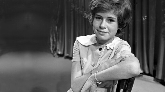 Die jugendliche Schlagersängerin Mary Roos sitzt auf einem Stuhl in den Kulissen zur TV-Sendung "Musik aus Studio B". © Picture-Alliance / United Archives Foto: Siegfried Pilz