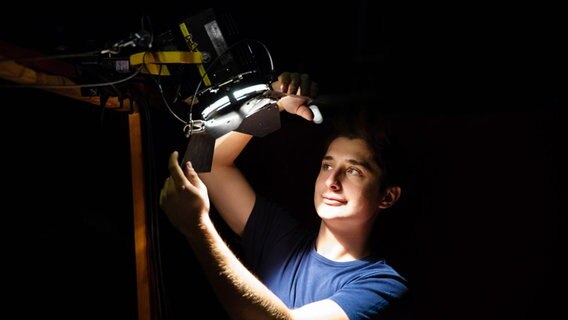 Ein Auszubildender der Veranstaltungstechnik sorgt für eine gute Lichtstimmung im Schuppen 52. © NDR Foto: Christian Spielmann
