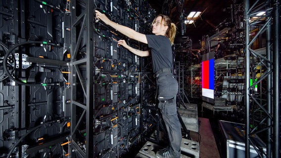 Die LED-Wände auf der Bühne werden rückseitig von einer Technikerin überprüft. © NDR Foto: Christian Spielmann