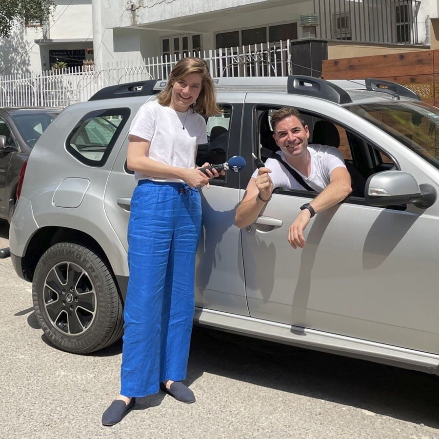 Neu Delhi Korrespondenten Charlotte Horn und Oliver Mayer stehen bzw. sitzen vor/in einem Auto © NDR Foto: Charlotte Horn