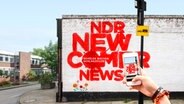 Mauer, auf der in roter Farbe NDR Newcomernews - Schüler machen Medien - steht.  