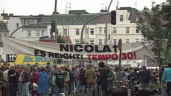 Demonstranten halten ein Transparent hoch um gegen die verfehlte Verkehrspolitik zu demonstrieren. © NDR Foto: Screenshot