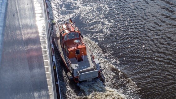 Ein Lotsenboot liegt an einer Schiffwand, um den Lotsen aufzunehmen. © NDR / Christine Raczka Foto: Christine Raczka