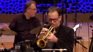 Screenshot: Claus Stötter von der NDR Bigband spielt beim Konzert "American Cool Jazz" in der Elbphilharmonie Hamburg das Flügelhorn. © NDR Bigband Foto: Screenshot