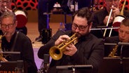 Screenshot aus dem Konzertmitschnitt aus der Elbphilharmonie Hamburg: Percy Pursglove von der NDR Bigband spielt Trompete. © NDR Bigband Foto: Screenshot