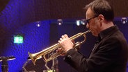 Screenshot: Claus Stötter von der NDR Bigband spielt beim Konzert "American Cool Jazz" in der Elbphilharmonie Hamburg die Trompete. © NDR Bigband Foto: Screenshot