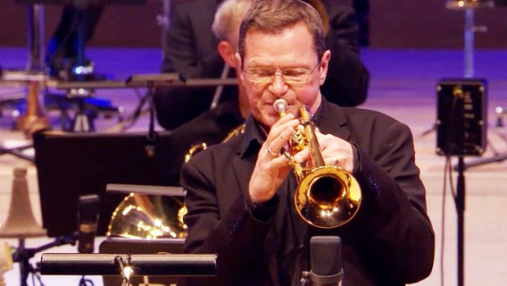 Screenshot aus dem Konzertmitschnitt aus der Elbphilharmonie Hamburg: Ingolf Burkhardt von der NDR Bigband spielt Trompete. © NDR Bigband Foto: Screenshot