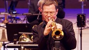 Screenshot aus dem Konzertmitschnitt aus der Elbphilharmonie Hamburg: Ingolf Burkhardt von der NDR Bigband spielt Trompete. © NDR Bigband Foto: Screenshot