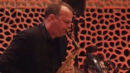 Screenshot aus dem Konzertmitschnitt aus der Elbphilharmonie Hamburg: Fiete Felsch von der NDR Bigband spielt Altsaxofon. © NDR Bigband Foto: Screenshot