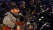 Der brasilianische Jazzmusiker João Bosco spielte im Jahr 2017 mit der NDR Bigband zum 25. Geburtstag des NDR in Schwerin. © NDR EO Foto: NDR/Screenshot