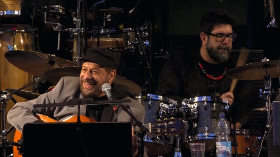 Der brasilianische Jazzmusiker João Bosco spielte im Jahr 2017 mit der NDR Bigband zum 25. Geburtstag des NDR in Schwerin. © NDR EO Foto: NDR/Screenshot