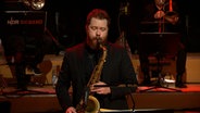 Screenshot: Tenorsaxofonist Matthew Halpin spielt mit der NDR Bigband während des Konzerts "A Different Christmas" am 17. Dezember 2020 im Rolf-Liebermann-Studio des NDR. © NDR Bigband Foto: Screenshot