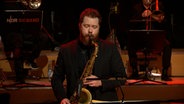 Screenshot: Tenorsaxofonist Matthew Halpin spielt mit der NDR Bigband während des Konzerts "A Different Christmas" am 17. Dezember 2020 im Rolf-Liebermann-Studio des NDR. © NDR Bigband Foto: Screenshot