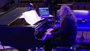 Screenshot: Der langjährige Pianist der NDR Bigband, Vladyslav Sendecki, spielt beim Konzert "Fusion Conclusion" am Klavier. © NDR Bigband Foto: Screenshot