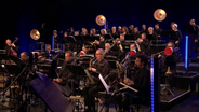 Im Vordergrund die Saxofonisten und Posaunen der NDR Bigband sowie im Hintergrund das NDR Vokalensemble. © NDR Foto: Screenshot