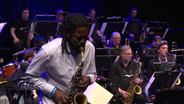 Screenshot: Soweto Kinch (TOYTOY) am Altsaxofon beim Konzert mit der NDR Bigband und TOYTOY auf Kampnagel. © NDR Bigband Foto: Screenshot