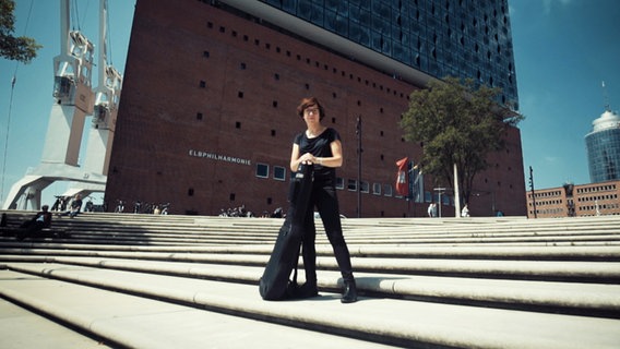 Screenshot: Sandra Hempel posiert auf einer Treppe vor der Elbphilharmonie. © NDR 