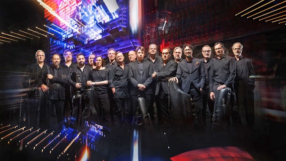 Mitglieder der NDR Bigband vor bunt beleuchtetem Hintergrund. © NDR/Maik Floeder 