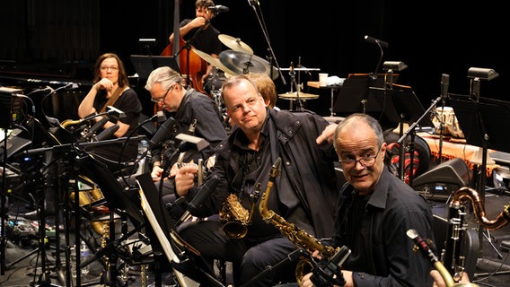 Probenszene: Blick auf die Reihe der Saxofonisten der NDR Bigband. Im Hintergrund: Gitarristin Sandra Hempel und Bassist Petros Klampanis. © NDR Foto: Ed Satterwhite