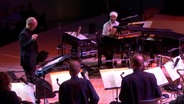 Omar Sosa am Flügel und die NDR Bigband mit Chefdirigent Geir Lysne beim Konzert in der Elbphilharmonie 2017 © NDR Foto: Screenshot