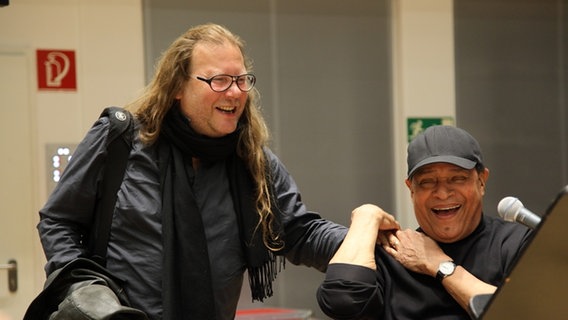 US-Jazzsänger Al Jarreau und Vladyslav Sendecki begrüßen sich bei einer Bandprobe in Hamburg. © NDR Bigband Foto: NDR Bigband