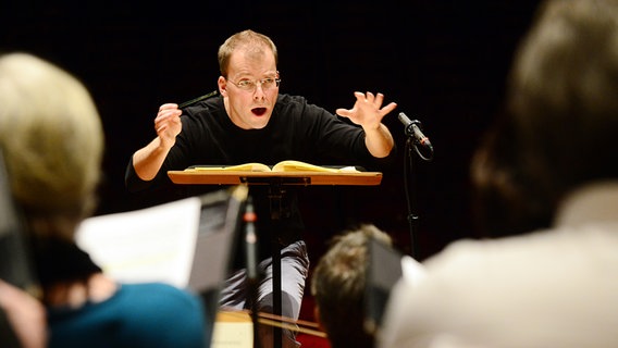 Bei der Probe: Philipp Ahmann hinter dem Dirigentenpult © NDR Foto: Falk von Traubenberg