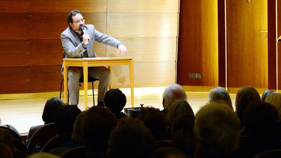 Blick über die Zuschauer auf die Bühne: Dr. Ilja Stephan bei der Einführungsveranstaltung im Kleinen Saal der Laeiszhalle © NDR Foto: Falk von Traubenberg