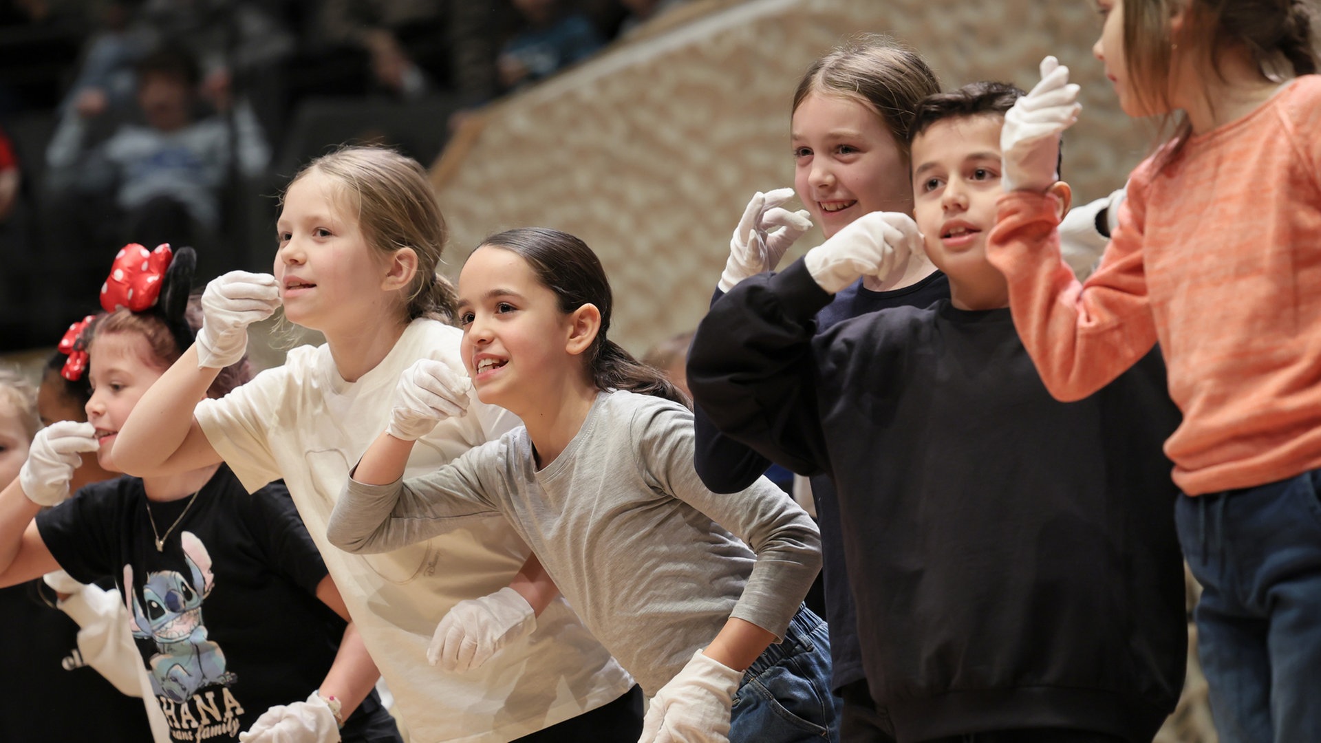 Konzertszene aus einem Schulkonzert: Kinder im Publikum gestikulieren Schlafen © NDR Foto: Marcus Krüger