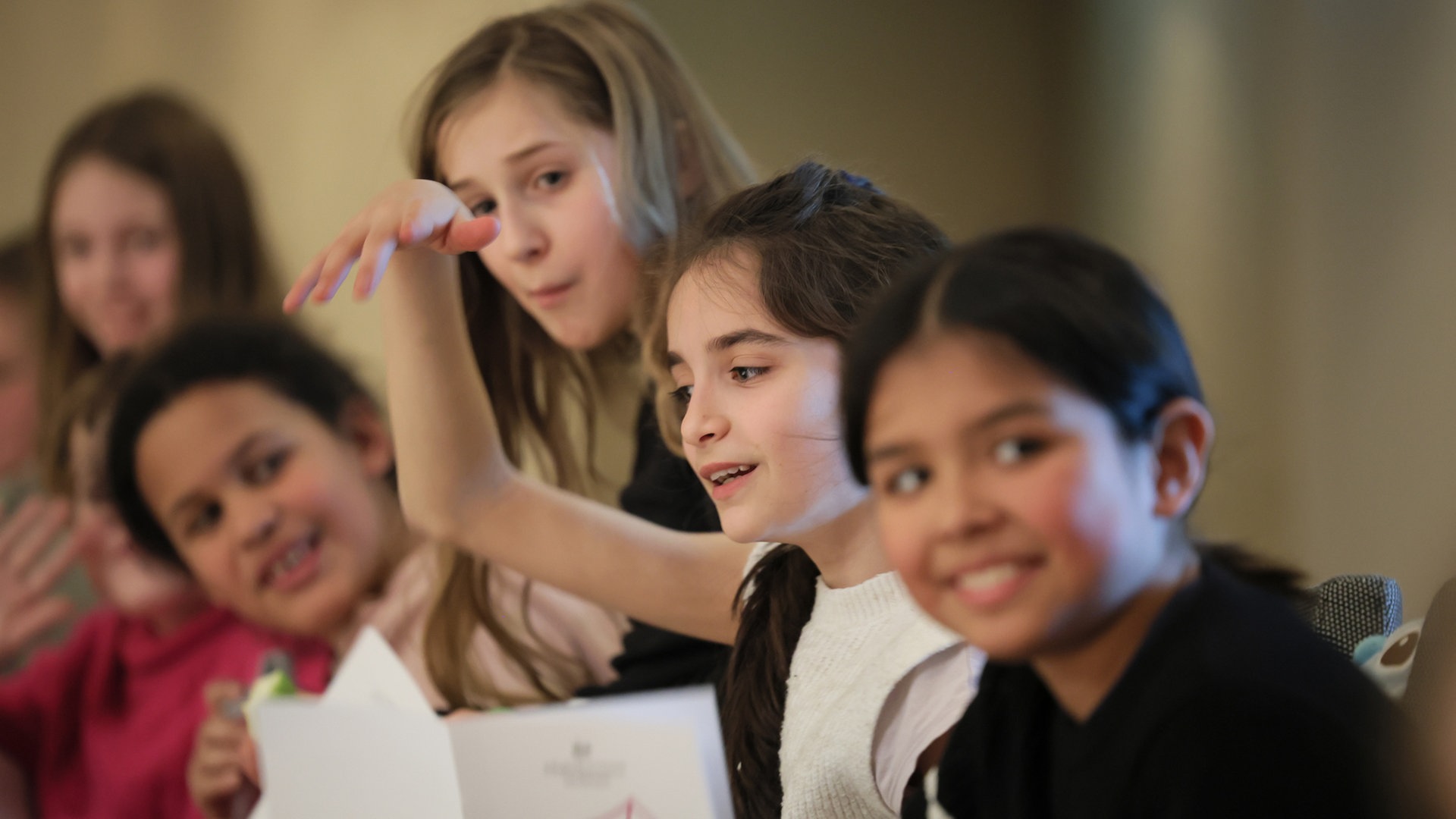 Konzertszene aus einem Konzert statt Schule: Kinder mit Programmheften gestukulieren im Publikum © NDR Foto: Marcus Krüger