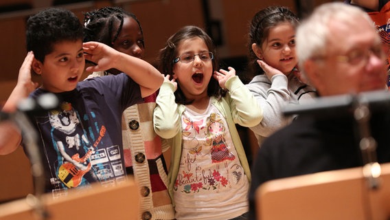 Kinder singen und halten ihre Hände hinter die Ohren. © NDR Foto: Marcus Krüger