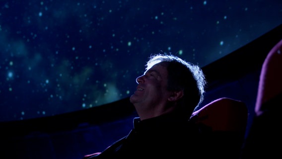 Screenshot: Wolfgang Ritter vom NDR Elbphilharmonie Orchester unter dem Sternenhimmel des Planetarium Hamburg © NDR Foto: Screenshot