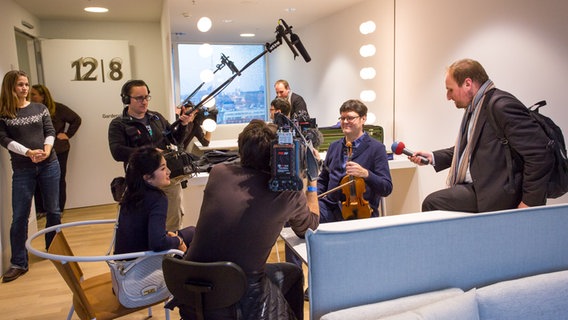 Backstage-Führung: Journalisten mit Mikrofonen und Kamera umringen Stefan Wagner im Konzertmeister-Zimmer in der Elbphilharmonie © NDR Foto: Axel Herzig